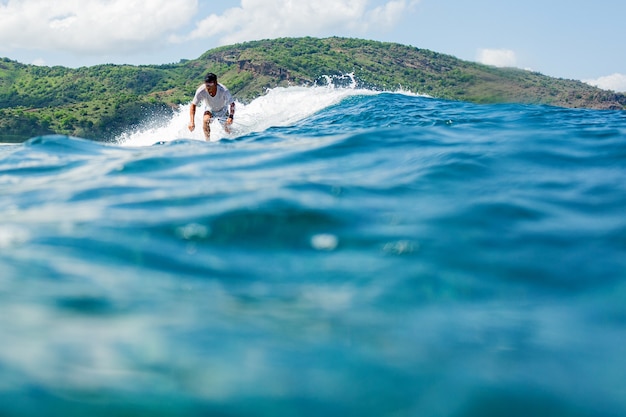 Surfer sur une vague bleue.