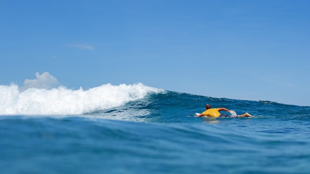 Surfer sur une vague bleue.