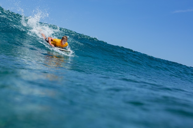 Surfer sur une vague bleue.