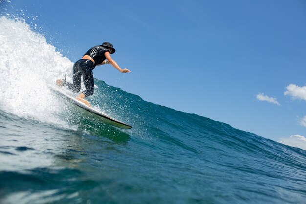 Surfer sur une vague bleue.