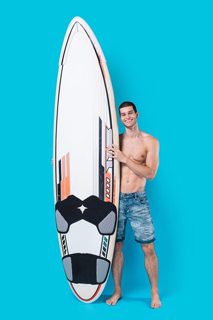 Surfeur souriant tenant une planche de surf