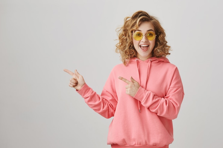 Photo gratuit surpris fille heureuse pointant vers la gauche, recommander la publicité du produit