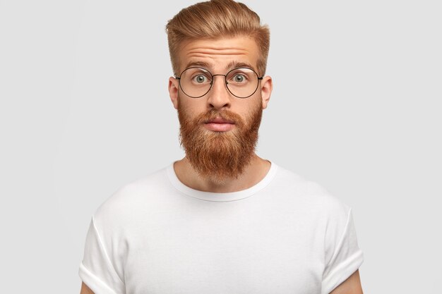 surpris jeune homme avec coupe de cheveux à la mode, a la barbe et la moustache de gingembre