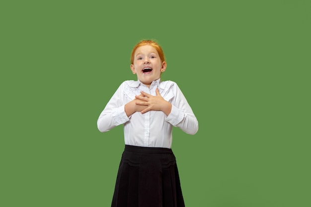 Surpris petite fille heureuse isolée sur mur vert