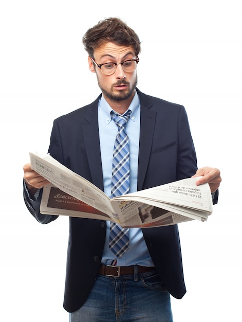 Surprised man en costume tout en lisant un journal