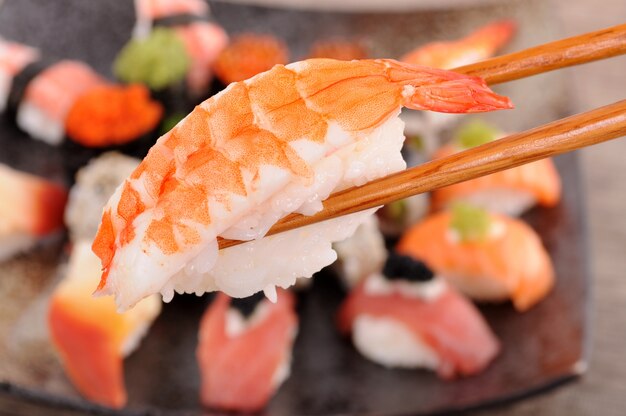 sushi Prawn tenue par des baguettes