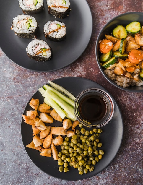Sushi vue grand angle avec assiettes de légumes