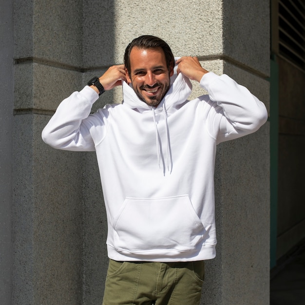 Photo gratuite sweat à capuche blanc sur l'homme avec un pantalon vert dans la ville