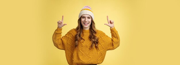 Sympathique charmante jeune femme énergisée s'habillant chandail chapeau élégant s'amusant à présenter la promotion