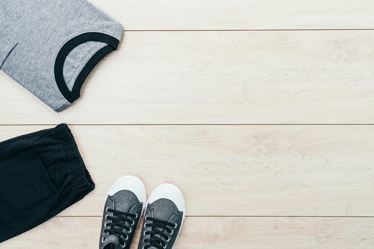 Photo gratuit t-shirt avec pantalons et chaussures sur fond de bois