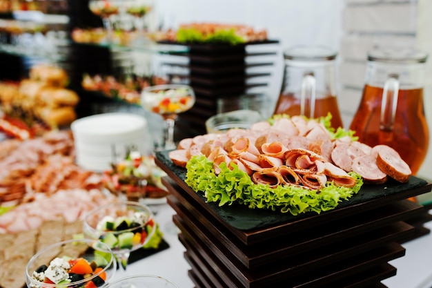 Table d'accueil buffet avec burgers snacks froids viandes et salades