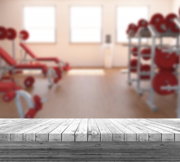 Table en bois blanc 3D donnant sur un intérieur de gym défocalisé