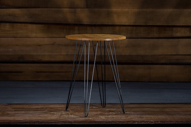 Table en bois avec des jambes en métal avec un mur en bois