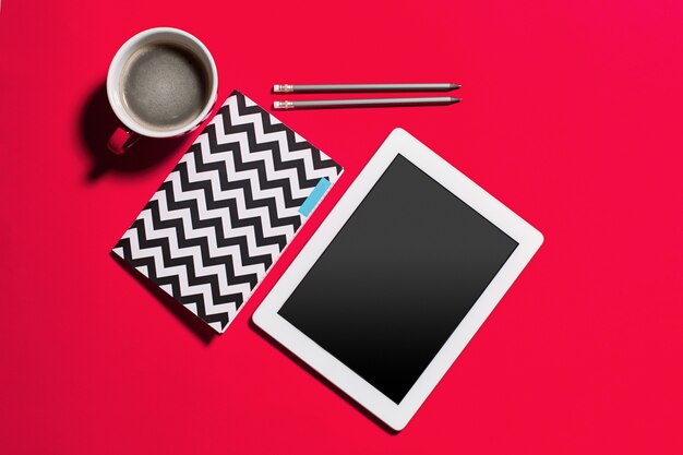 Table de bureau de bureau rouge moderne avec smartphone et tasse de café.