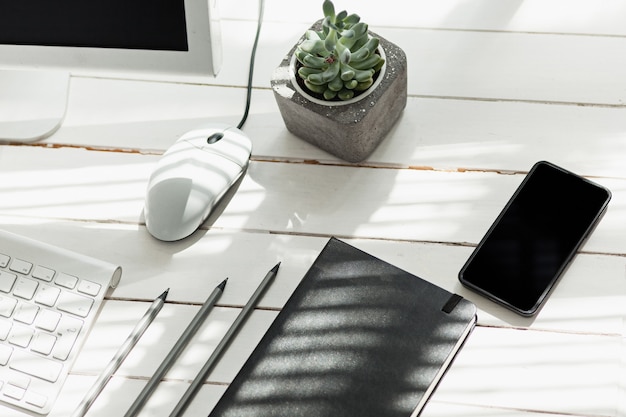 Table de bureau avec ordinateur, fournitures et téléphone