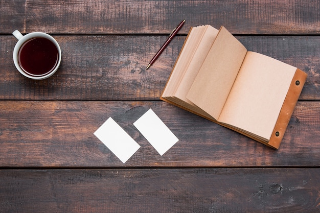 Table de bureau avec tasse, ordinateur portable, cartes sur table en bois