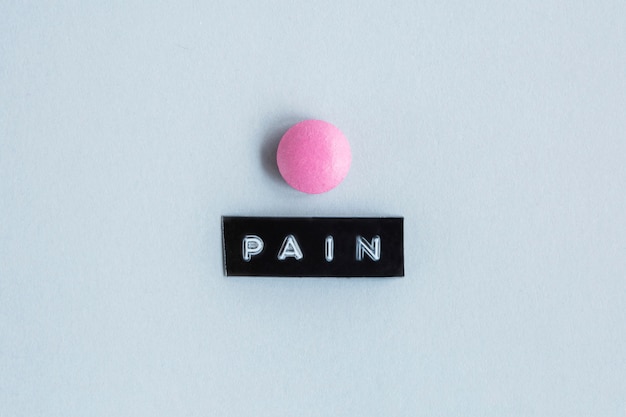 Photo gratuite table de couleur rose avec étiquette de la douleur