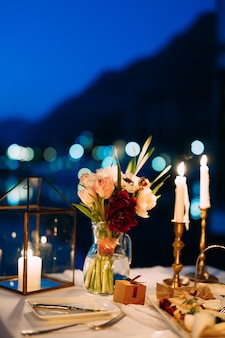 Table de dîner de mariage réception un bouquet de fleurs dans un vase en verre sur la table la nuit blanche