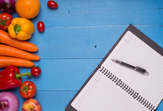 Table avec des légumes et un bloc-notes