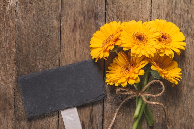 Photo gratuite table avec plaque et fleurs