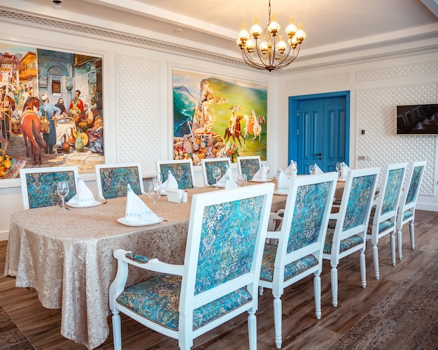 Photo gratuite table de restaurant avec chaises classiques blanches et tissu turquoise