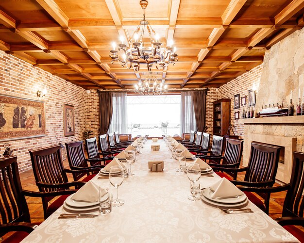 Table de restaurant dans la salle privée avec cheminée, plafonds en bois et murs en briques