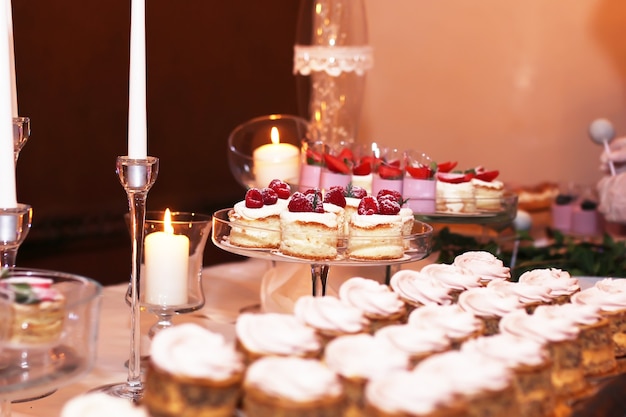 Table de restauration avec des gâteaux au chocolat tranchés décorés de framboises fraîches et de noix.