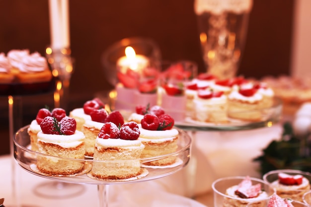 Table de restauration avec des gâteaux au chocolat tranchés décorés de framboises fraîches et de noix.