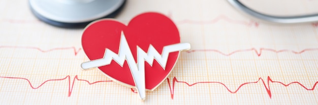 Sur la table se trouve le cardiogramme stéthoscope et le coeur signe le concept de maladie cardiaque et vasculaire