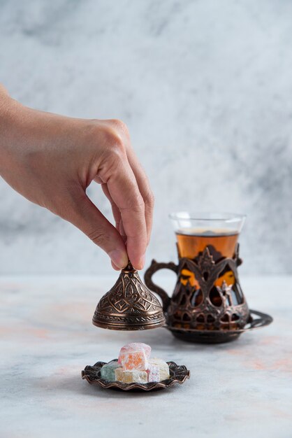 Table de thé. Homme ouvrant la vaisselle de bonbons à côté de thé