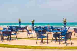 Photo gratuite table vide et chaise autour du fond de la plage