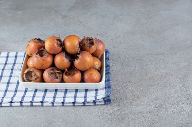 Un tableau blanc avec des kakis mûrs sur une nappe. photo de haute qualité