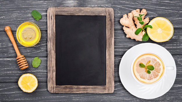 Tableau à côté de la tasse de thé au citron et de miel