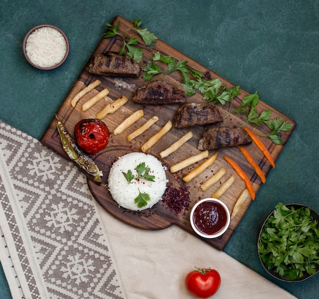 Tableau de kebab vue de dessus avec des aliments grillés.