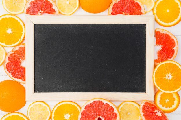 Tableau noir parmi les pamplemousses frais et les oranges