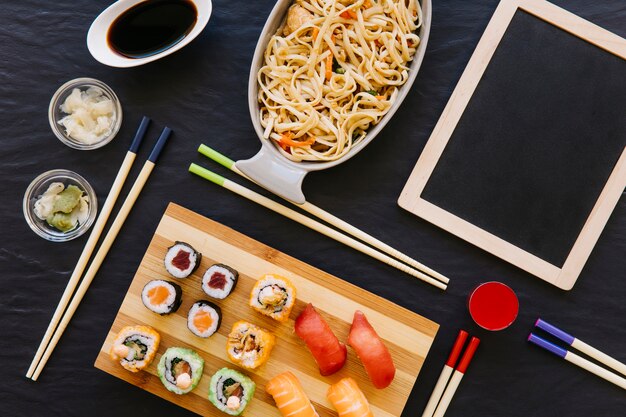 Tableau noir près des sushis et des nouilles