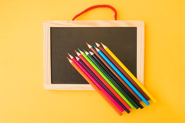 Tableau noir sous des crayons de couleur