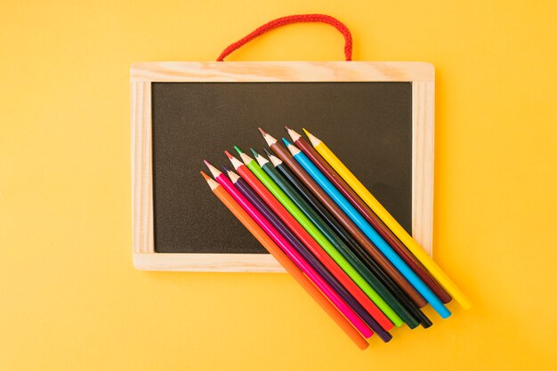 Tableau noir sous des crayons de couleur