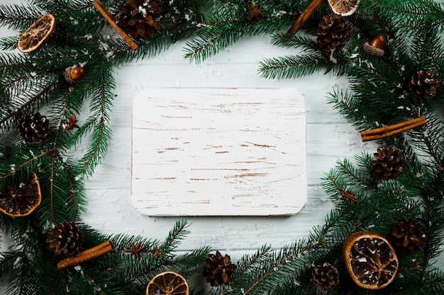 Photo gratuite tablette de bois entre les branches de sapin