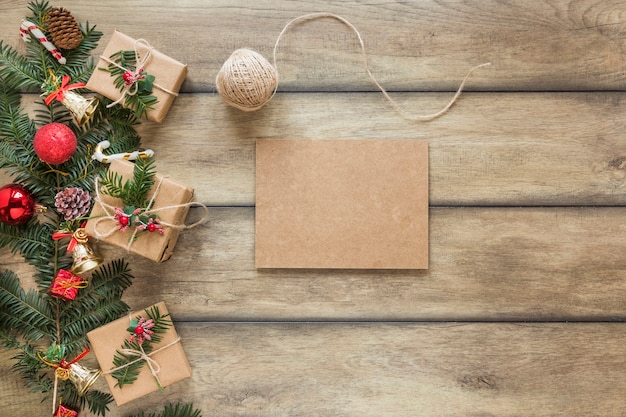 Tablette en carton près d&#39;une branche de sapin décorée de jouets de Noël