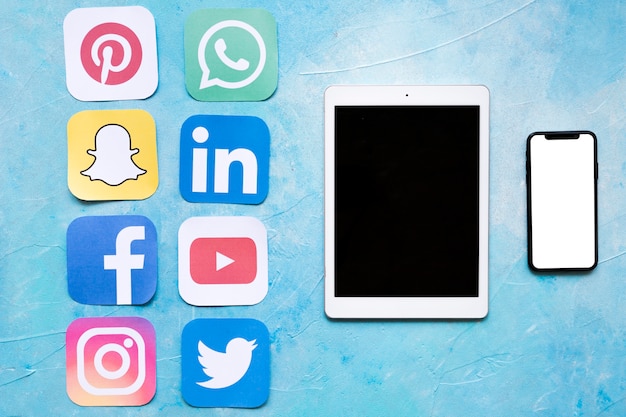 Tablette Dgital et téléphone portable près d&#39;autocollants d&#39;icônes de médias sociaux
