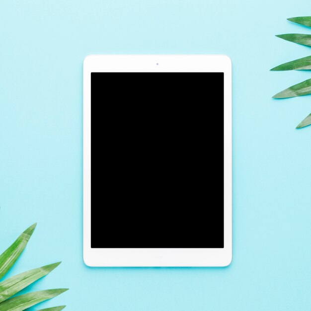 Tablette avec des feuilles tropicales sur un fond clair