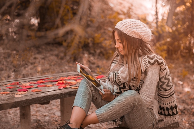 Tablette de navigation femme près de la table dans le parc