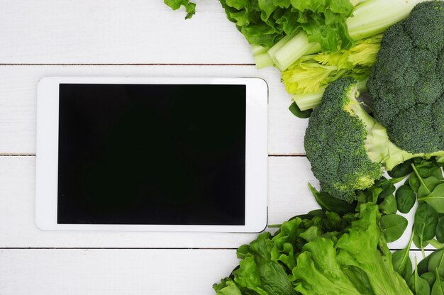 Tablette numérique avec écran noir et légumes, concept d'aliments sains