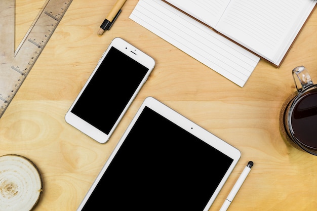 Photo gratuite tablette avec smartphone avec ordinateur portable sur une table en bois