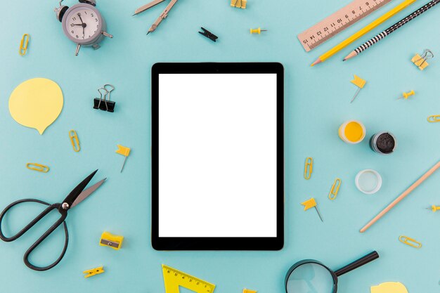 Tablette vue de dessus entourée de fournitures de bureau