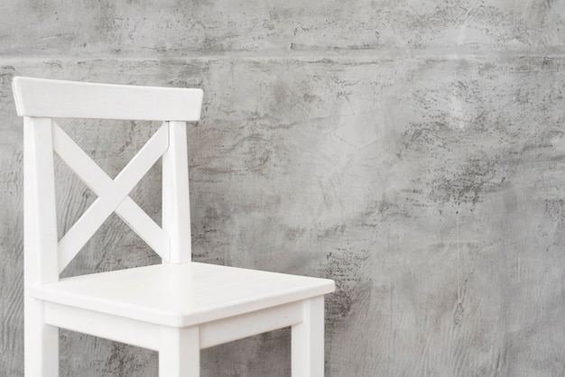 Photo gratuite tabouret blanc minimaliste avec panneaux en béton