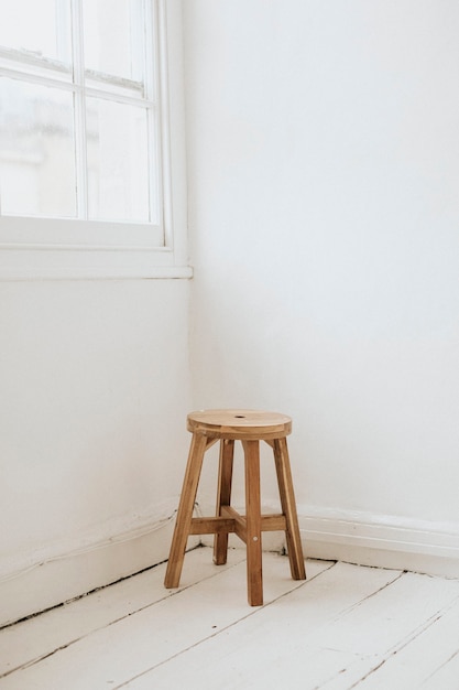 Photo gratuite tabouret en bois dans le coin d'une pièce