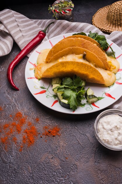 Taco parmi les légumes sur le plat près du piment et sauce avec serviette