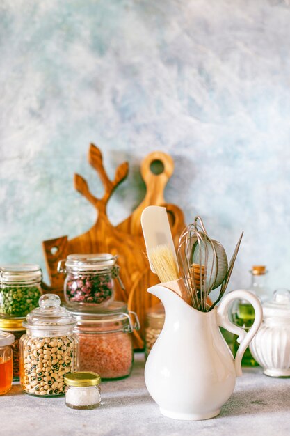 Étagère de cuisine avec diverses herbes, épices, graines, légumineuses, planches à découper